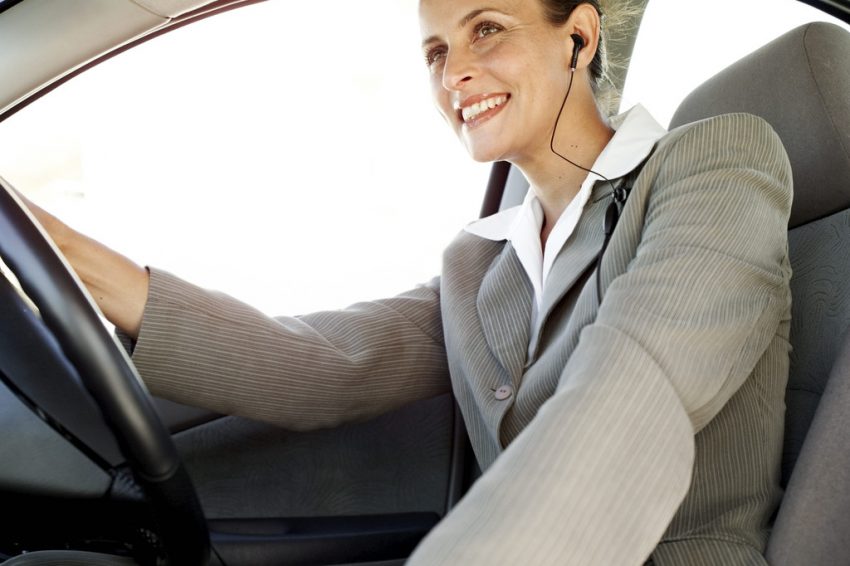 Woman Driving a Car and Wearing Earphones