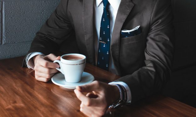 Director’s fees: What and How To Pay Them man exec suit coffee